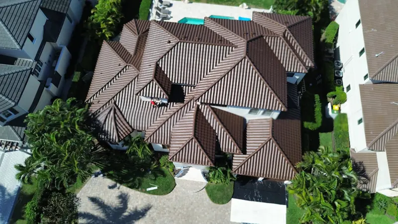 Aerial view of a brown tile roof after painting on a waterfront home