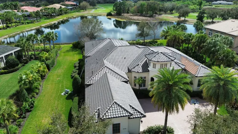 Aerial view of a lakefront estate with a gray tile roof