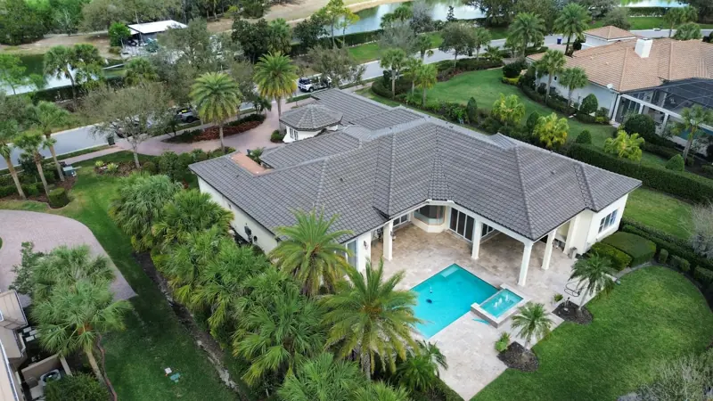Aerial view of an estate with a gray tile roof and pool in Lakewood Ranch