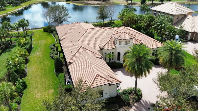 Aerial view of a lakefront estate with terracotta tile roof after painting