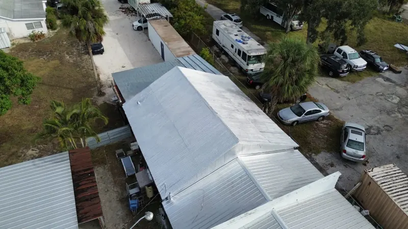 Aerial view of a mobile home with a white metal roof after painting
