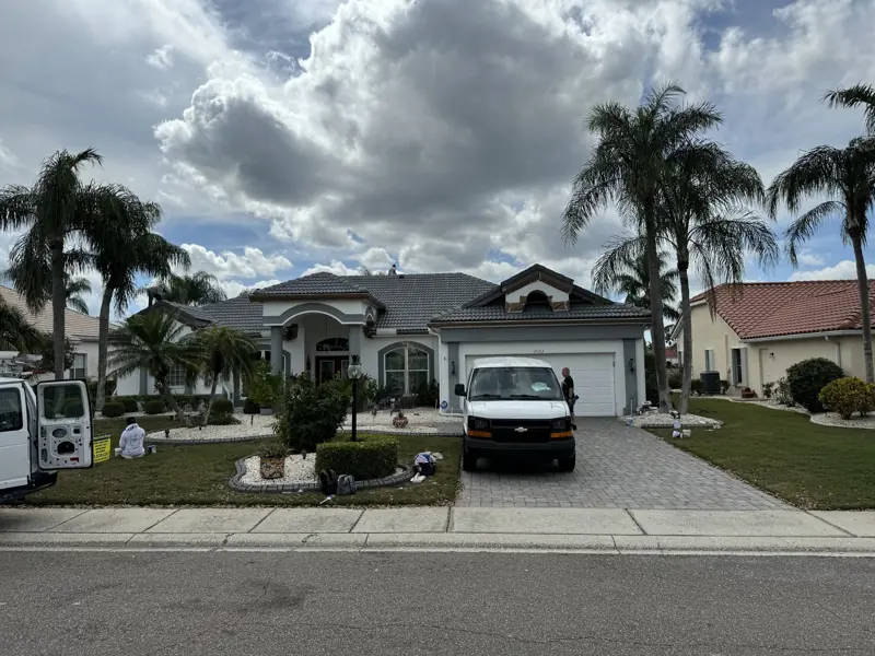 Corrigan Custom Painting crew van at a white home during exterior painting in Sarasota