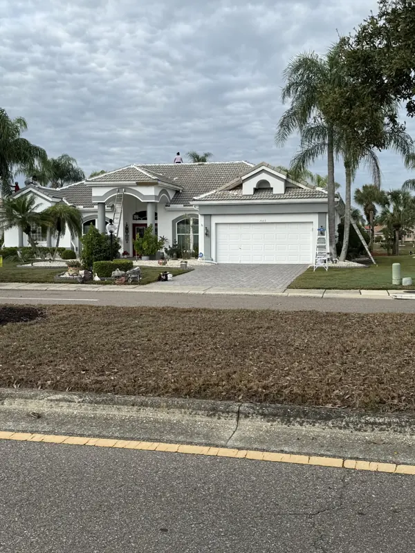 White Sarasota home with a gray tile roof after painting