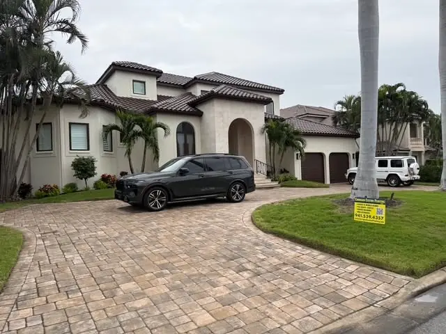 Mediterranean estate with paver driveway and painted tile roof