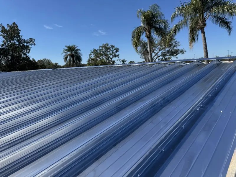 Freshly painted metal roof panels under a blue Florida sky
