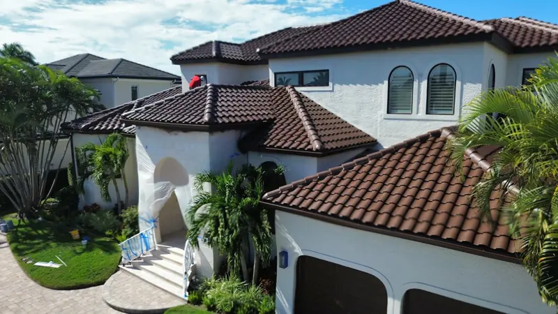 Painter on the tile roof of a Mediterranean style home