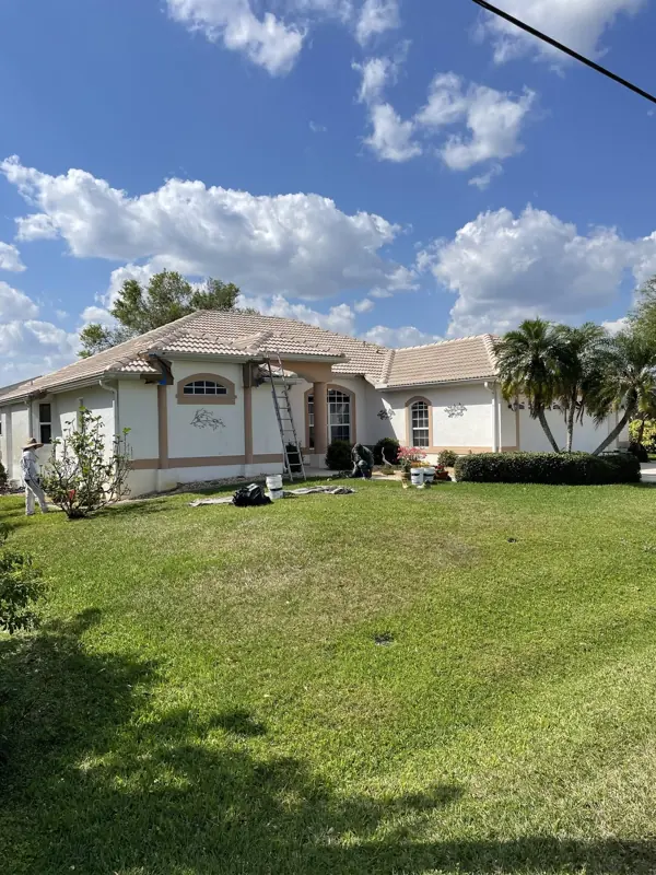 Stucco home with tile roof painting in progress