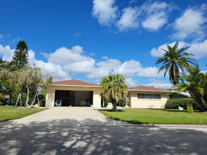 Tan stucco ranch home with brown tile roof, exterior painting job site in Sarasota