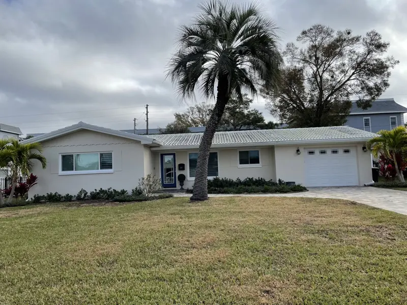 White mid-century home with a freshly painted roof
