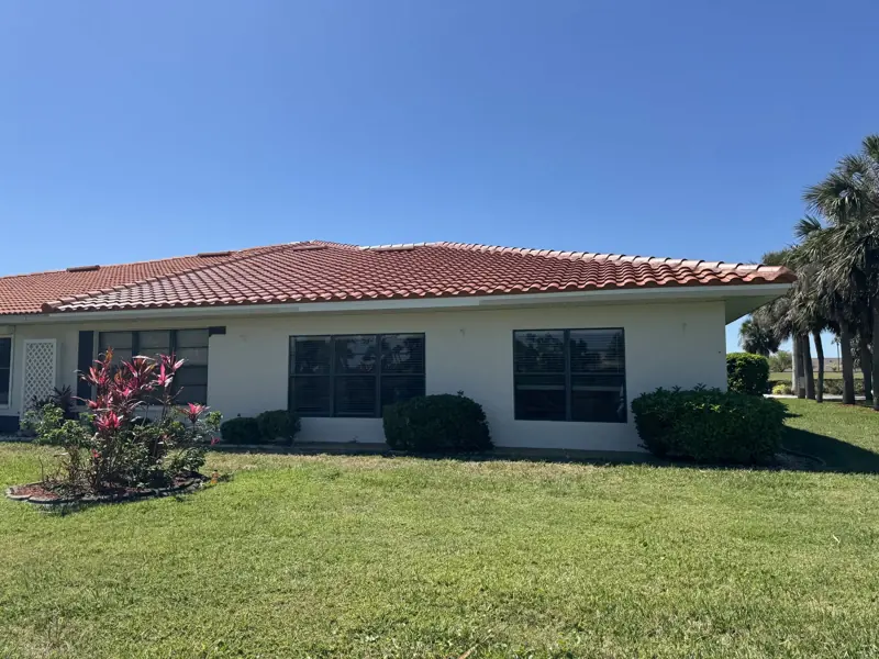 Yellow stucco home with terracotta tile roof after painting